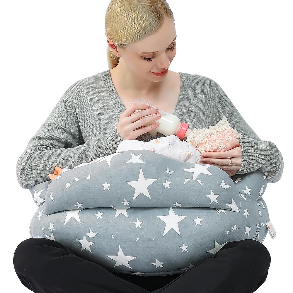 A mother feeding her baby on a star-shaped breastfeeding pillow.